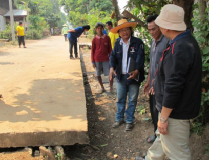 Thaithong water run off channel on right of picture in disrepair and flood water threatens to damage concrete road.